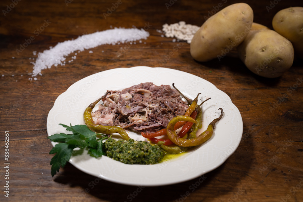Boiled lampredotto with green sauce and pickled peppers from the table of an old tavern