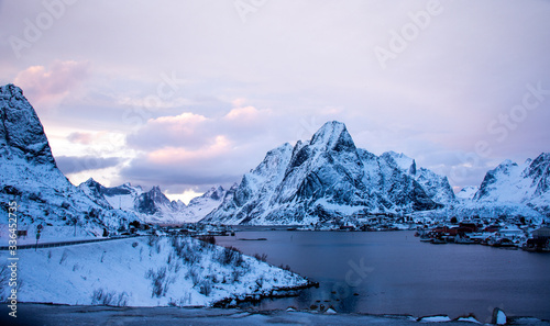 Canvas Print view of the snowy mountains and the sea in winter as night falls in Reine, Lofo