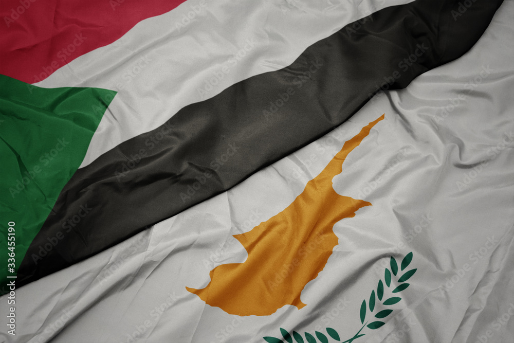 waving colorful flag of cyprus and national flag of sudan.