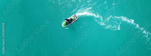 Aerial drone top down ultra wide photo of jet ski watercraft cruising in low speed in tropical exotic lake with calm emerald waters © aerial-drone