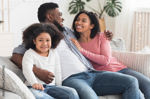Cute Little African American Girl Relaxing At Home With Her Parents