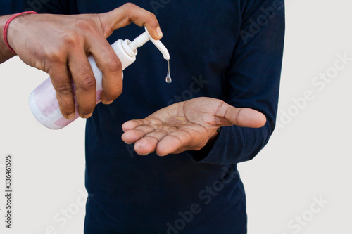 Young boy washing hands with hand sanitizer to avoid Corona virus
 photo