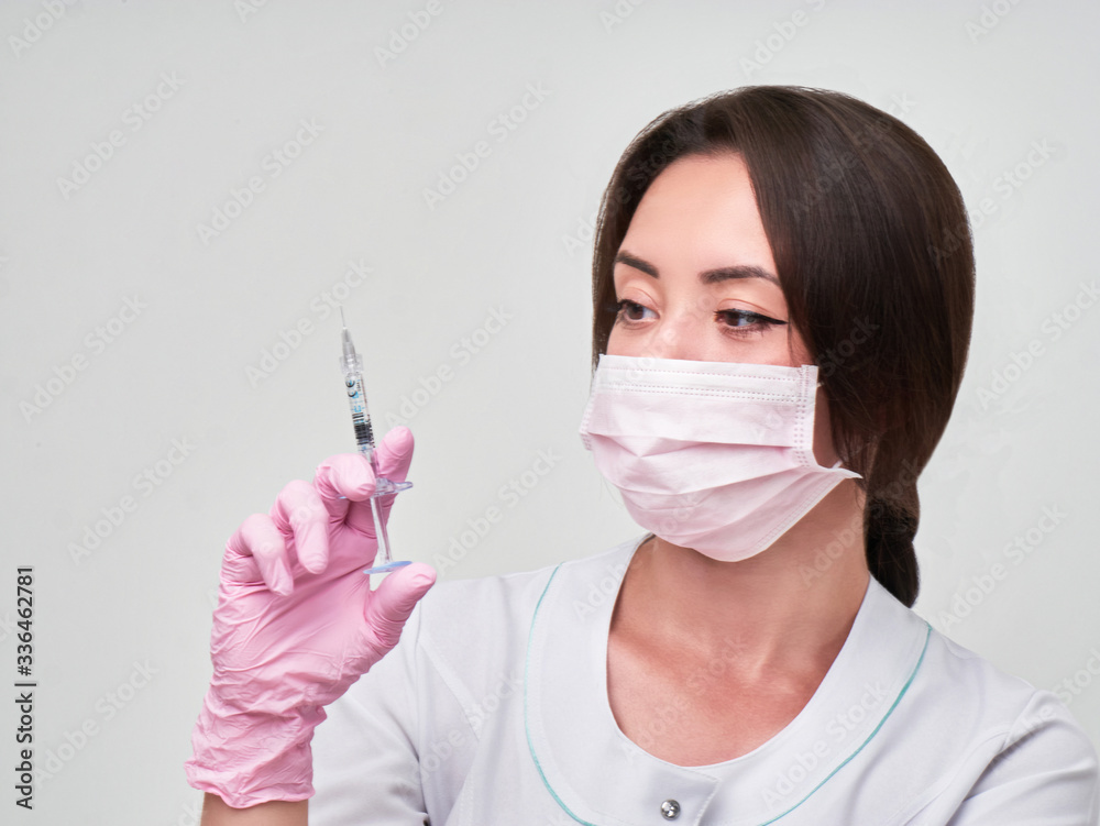 Doctor in a medical mask and rubber gloves with syringe. Virus, coronavirus. protection Doctor in a medical mask and rubber gloves with syringe. Virus, coronavirus. protection
