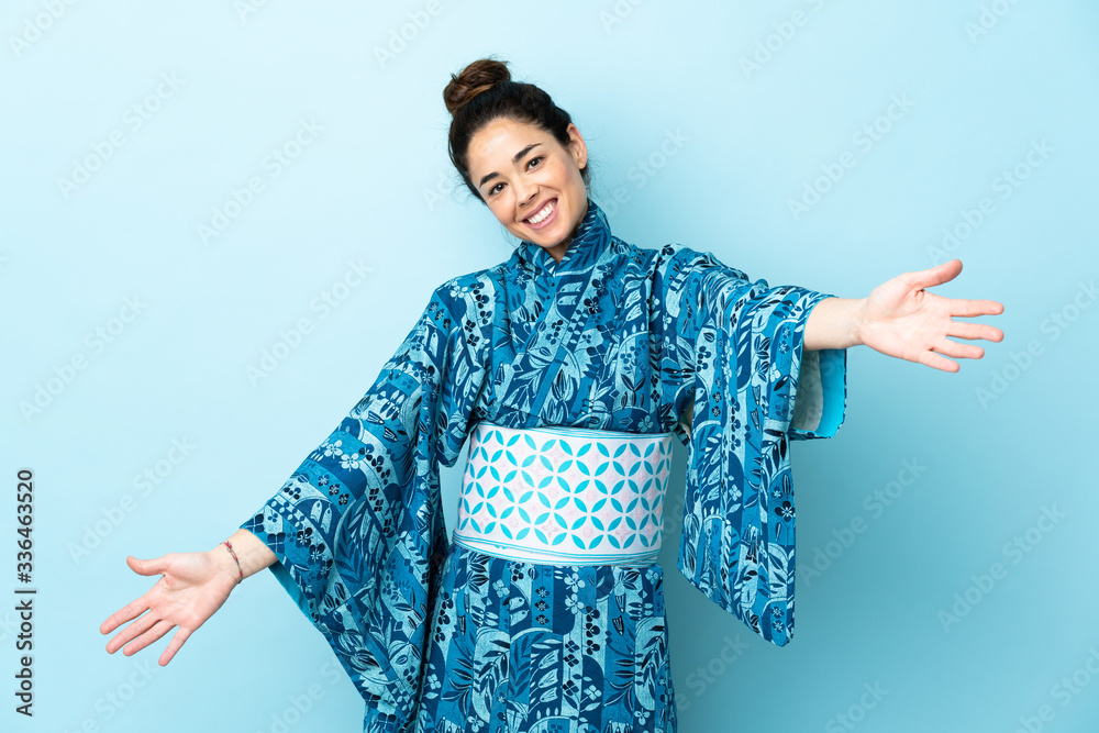 Woman wearing kimono over isolated background presenting and inviting to come with hand Woman wearing kimono over isolated background presenting and inviting to come with hand