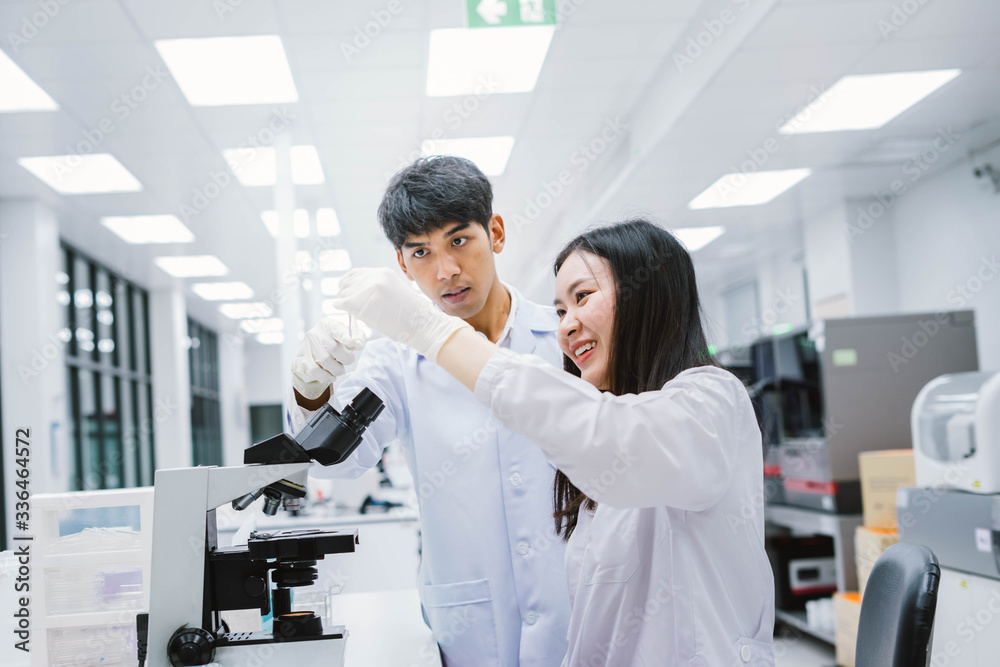 Fototapeta premium Two medical scientist looking at test tube. select focus in young female scientist