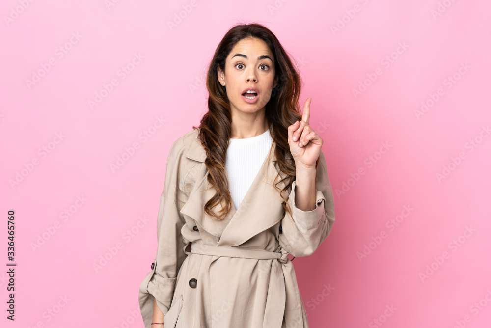 Woman over isolated background thinking an idea pointing the finger up