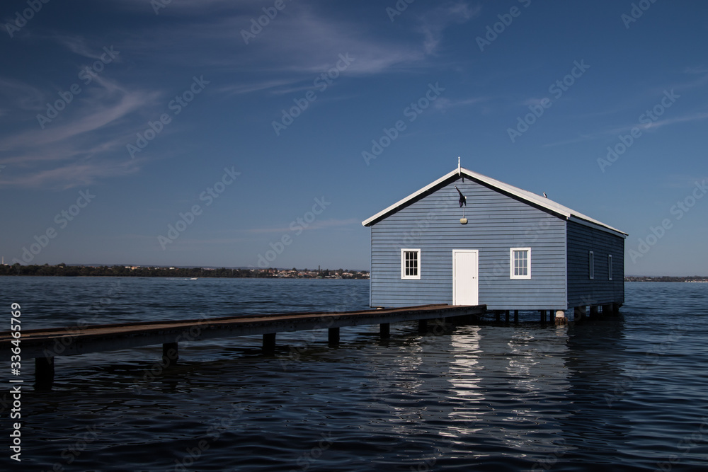 Peculiar house sitting over the water on clear summer day