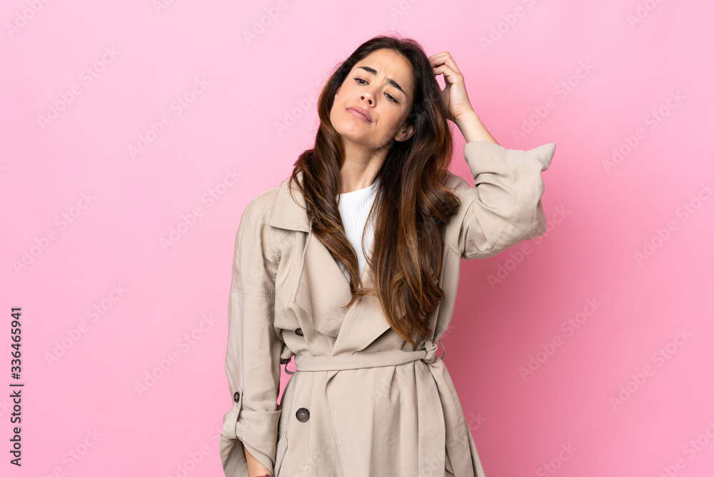 Woman over isolated background having doubts while scratching head Woman over isolated background having doubts while scratching head