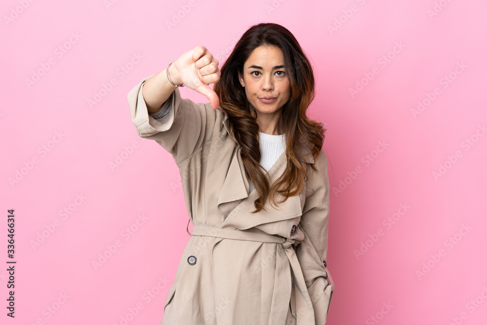 Woman over isolated background showing thumb down with negative expression Woman over isolated background showing thumb down with negative expression
