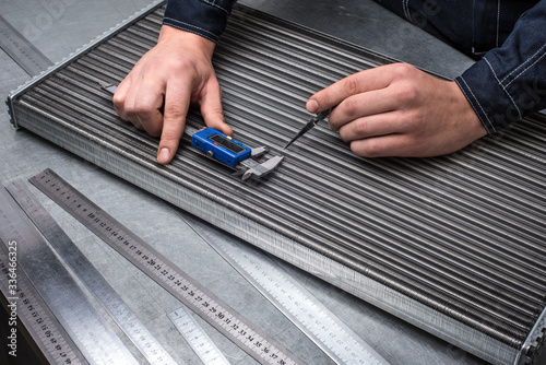 Checking car cooling radiator with calliper, quality control