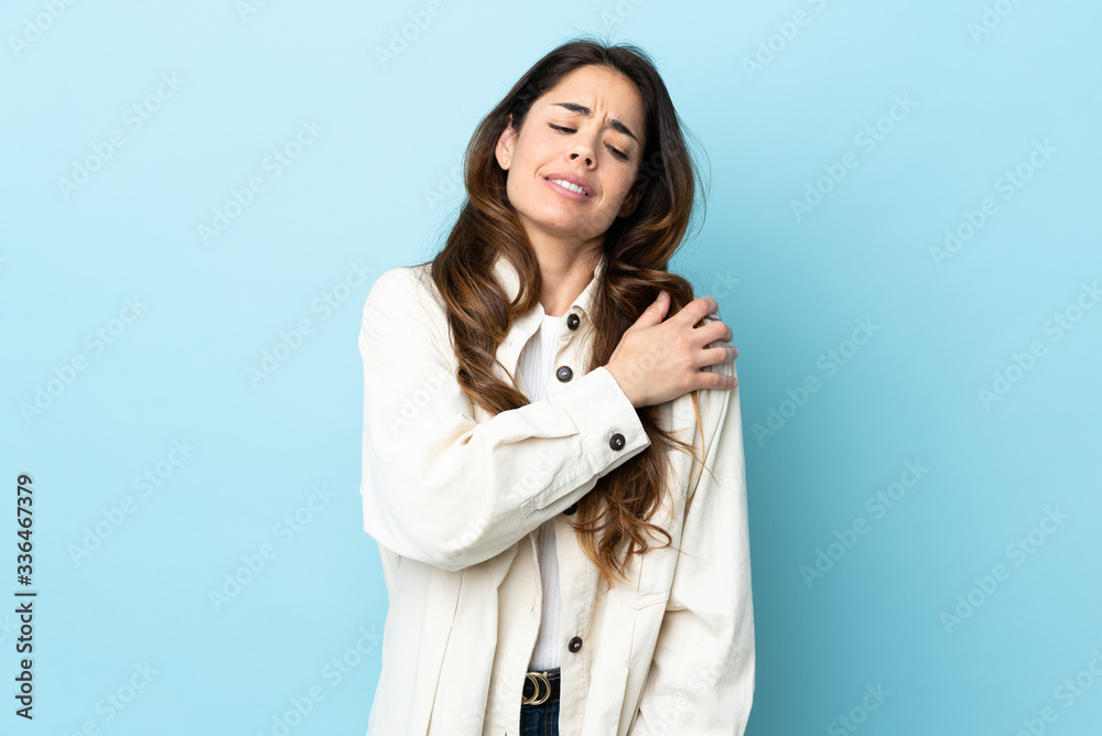 Woman over isolated background suffering from pain in shoulder for having made an effort Woman over isolated background suffering from pain in shoulder for having made an effort