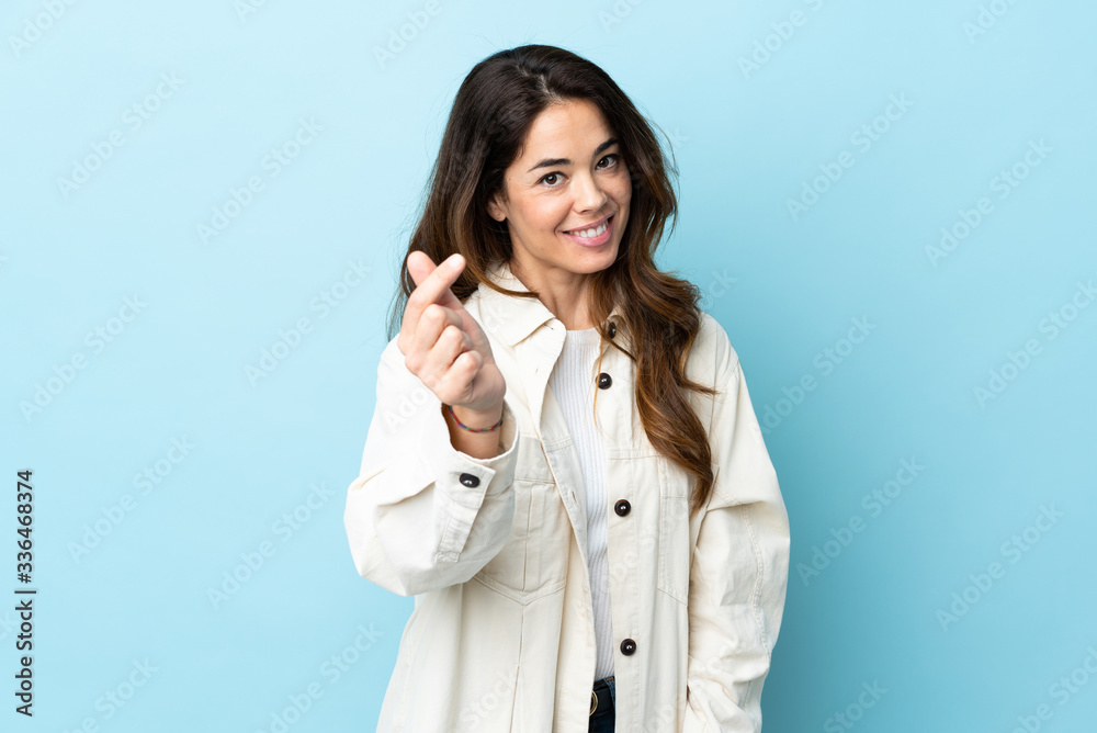 Woman over isolated background making money gesture Woman over isolated background making money gesture