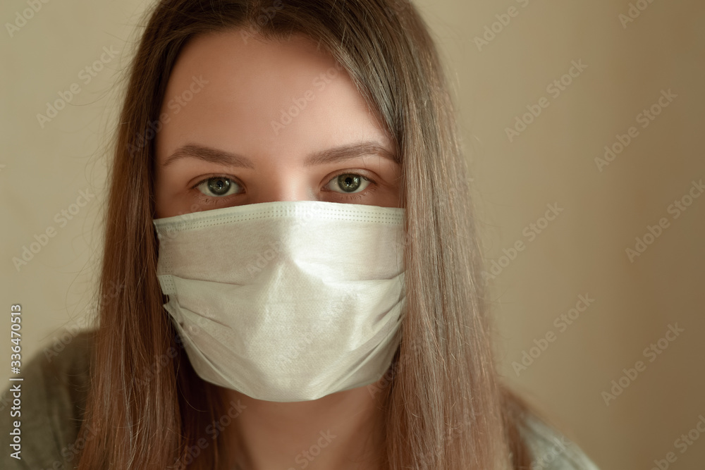 Young woman with protection medical mask looking at camera. Stay at home for quarantine to prevent coronavirus spread. Concept for protect from infection, respiratory disease, virus or bacteria. Young woman with protection medical mask looking at camera. Stay at home for quarantine to prevent coronavirus spread. Concept for protect from infection, respiratory disease, virus or bacteria.