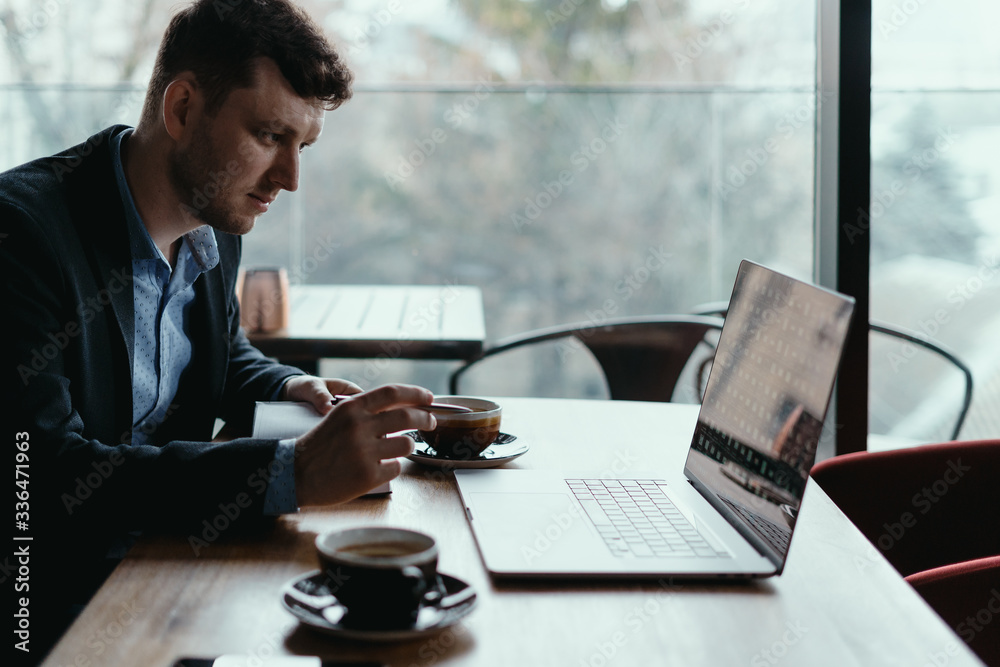 Cropped shot of businessman typing on laptop computer in a comfortable workplace cafe with window wooden desk background Cropped shot of businessman typing on laptop computer in a comfortable workplace cafe with window wooden desk background