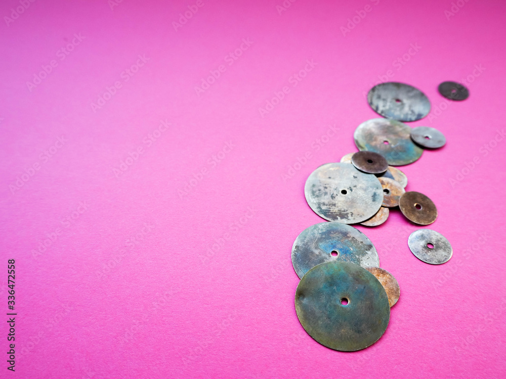 round metal decor elements on a pink background