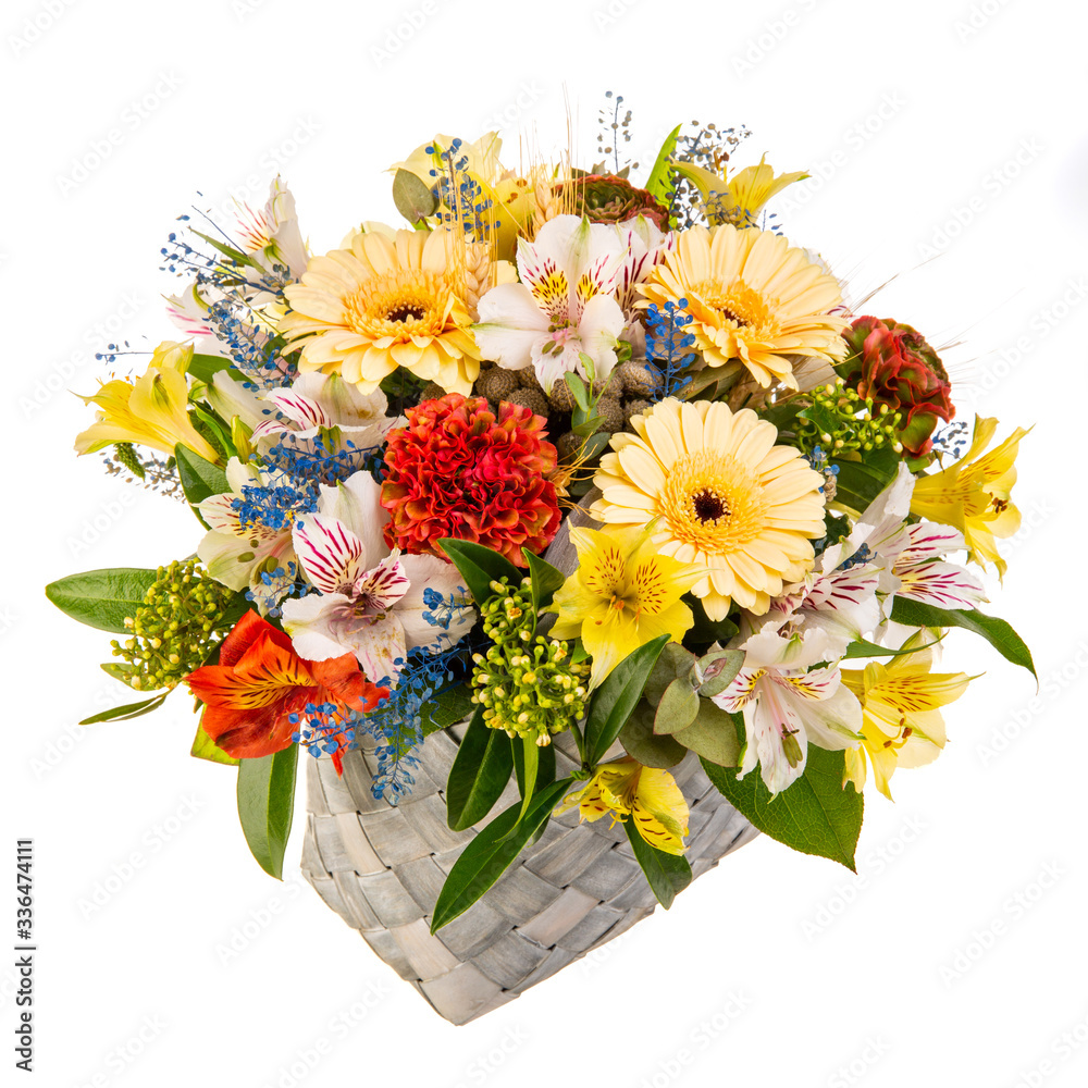 Bouquet of flowers in a braided high basket with greenery