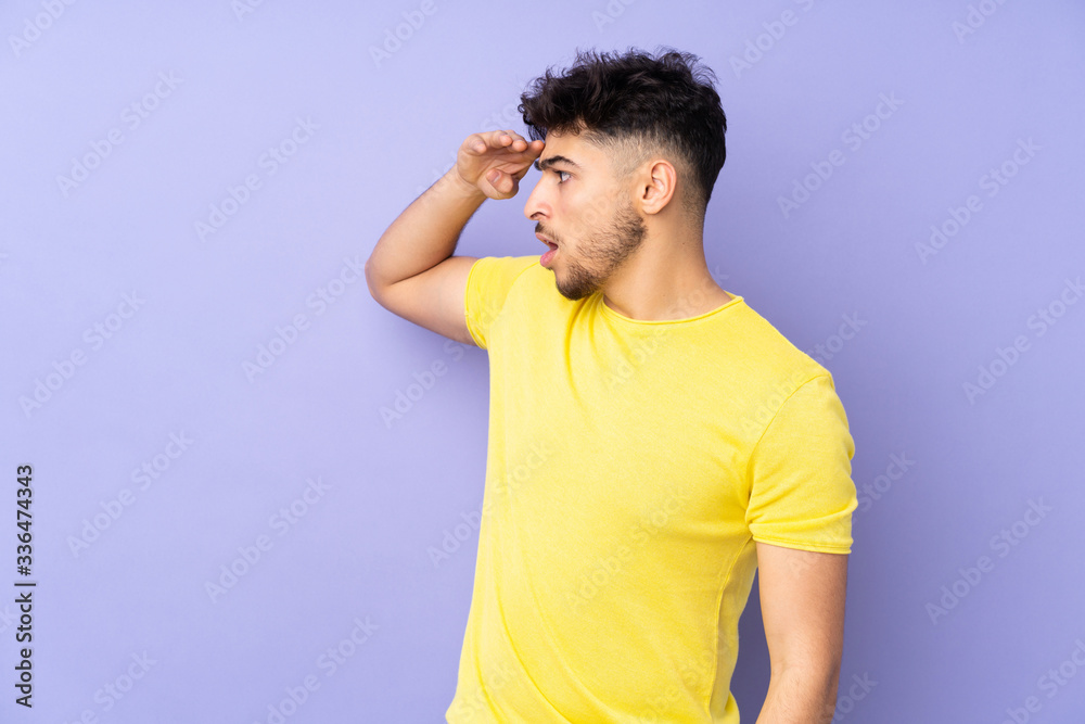 Arabian handsome man over isolated background with surprise expression while looking side Arabian handsome man over isolated background with surprise expression while looking side