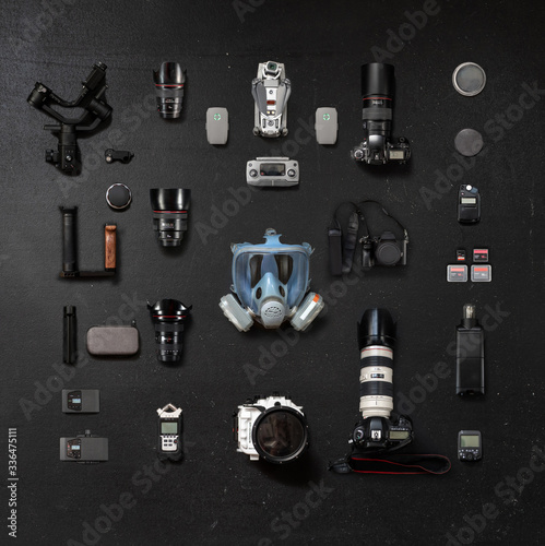 Obraz na płótnie Protective mask and a collection of lenses and photo camera on a black background w salonie