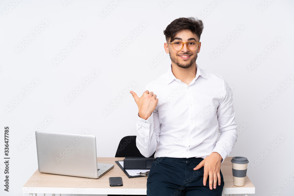Arabian man in a office isolated on white background pointing to the side to present a product Arabian man in a office isolated on white background pointing to the side to present a product