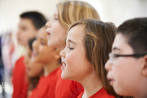 Group Of School Children Singing In Choir At Stage School Together
