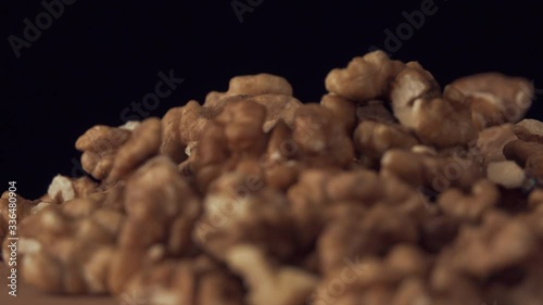 Walnut closeup. Walnut is crushed clockwise on a black background. Walnut closeup. Correctly the power on the conveyor moves.