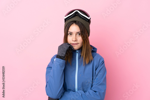 Young skier woman over isolated pink background nervous and scared