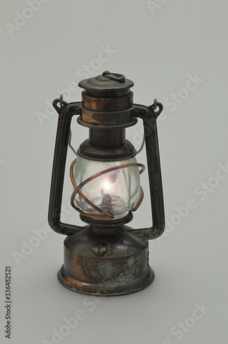 Retro Oil lamp, illuminated, isolated on gray Background, vertical