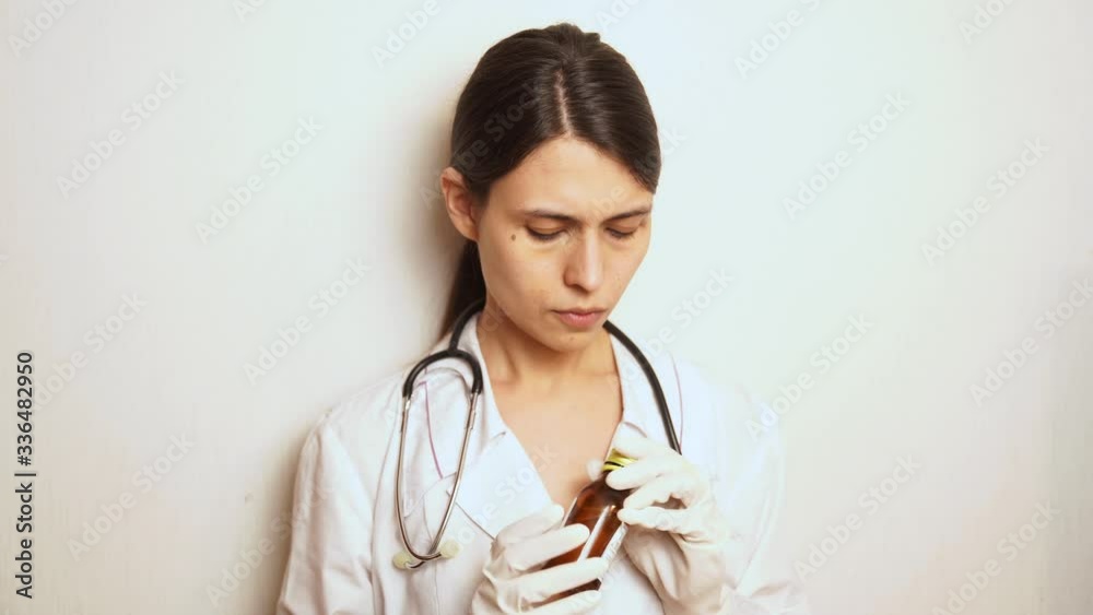 doctor a woman in rubber disposable gloves takes a disinfectant and treats her hands, takes a disposable syringe and dials the necessary medicine into the syringe doctor a woman in rubber disposable gloves takes a disinfectant and treats her hands, takes a disposable syringe and dials the necessary medicine into the syringe