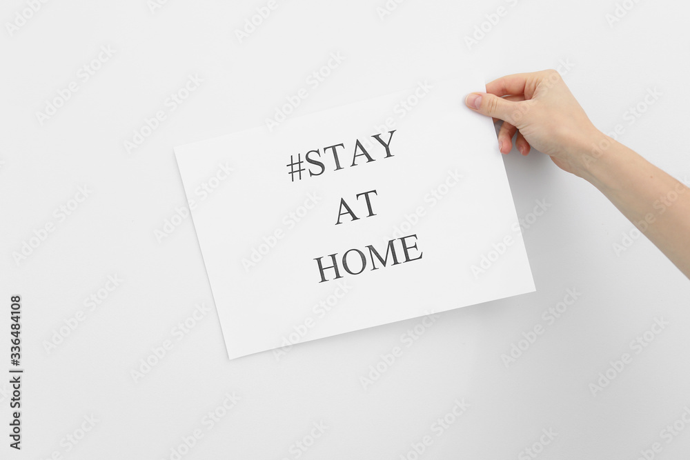 stay at home concept. woman hand holding paper with words stay at home isolated on white background. Coronavirus, COVID-19, self-quarantine, isolation stay at home concept. woman hand holding paper with words stay at home isolated on white background. Coronavirus, COVID-19, self-quarantine, isolation