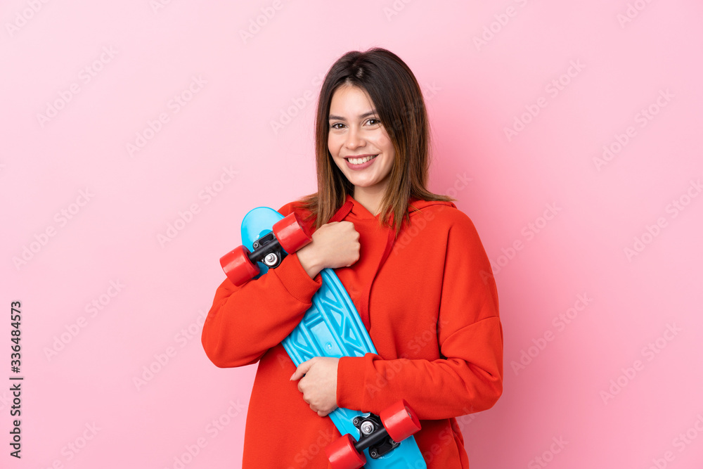 Young skater woman over isolated pink background Young skater woman over isolated pink background
