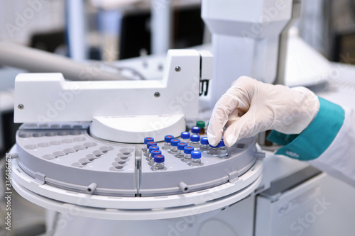 Quality Control Laboratory medicine. Chromatograph operation. A woman makes an analysis on a gas chromatograph. Development of a new vaccine against the covid-19 virus. photo