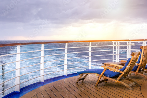 Cruise ship wooden deck chairson the main deck at sunset © Martina