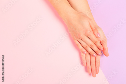 female  manicure. Beautiful young woman's hands on pastel pink  background - Image
