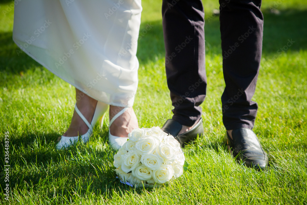 Wedding bouquet of the bride and feet newlyweds Wedding bouquet of the bride and feet newlyweds