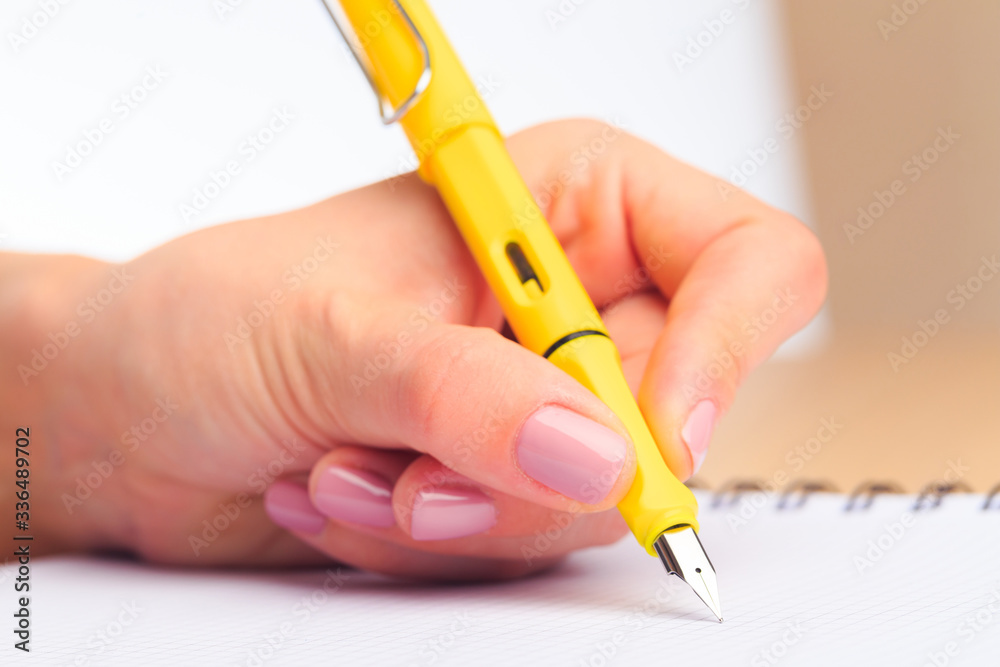 female hands write in a notebook . Office place - Image female hands write in a notebook . Office place - Image