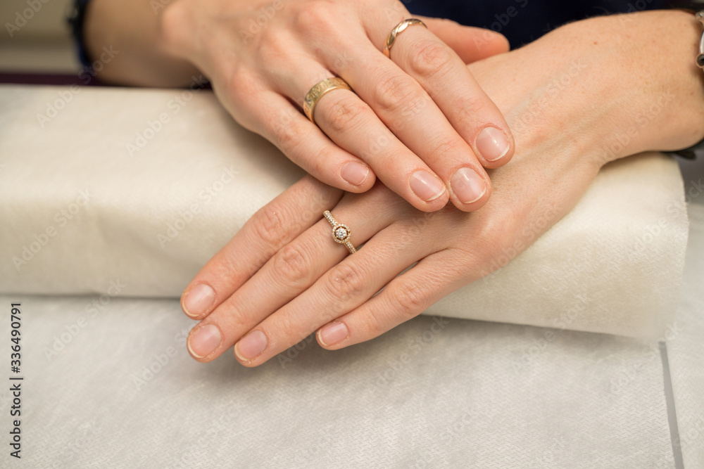 Woman hands in a nail salon receiving a manicure. Nail filing. Close up