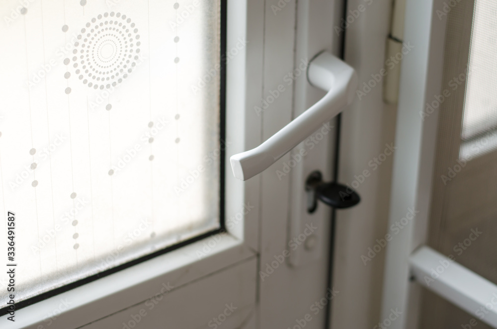 Part of a plastic door. The key is inserted in the door lock. Real estate purchase and sale concept. Front door window. Part of a plastic door. The key is inserted in the door lock. Real estate purchase and sale concept. Front door window.