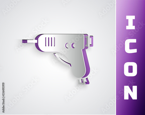 Paper cut Electric hot glue gun icon isolated on grey background. Hot pistol glue. Hot repair work appliance silicone. Paper art style. Vector Illustration