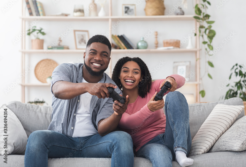 Cheerful black couple having fun at quarantine, competing in video games Cheerful black couple having fun at quarantine, competing in video games