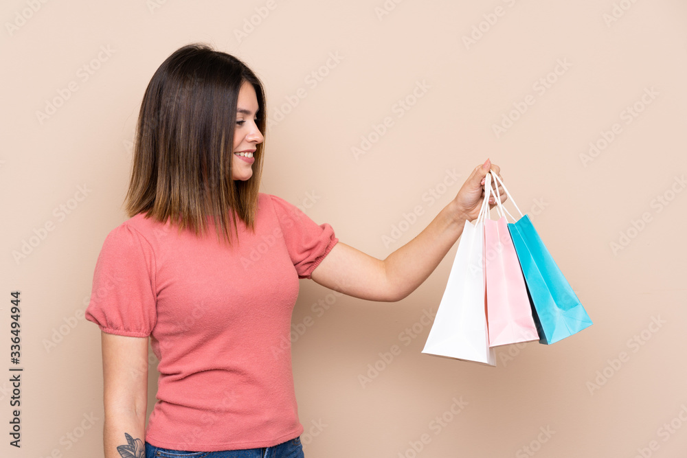 Young woman with shopping bag over isolated background with happy expression
