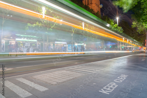 Blurred image of city tram whizzing past keep clear sign on pavement