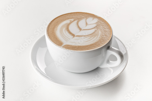 Cappuccino coffee with latte art on top in white ceramic mug. White background. Best for commercial. Content for coffee addicted guys