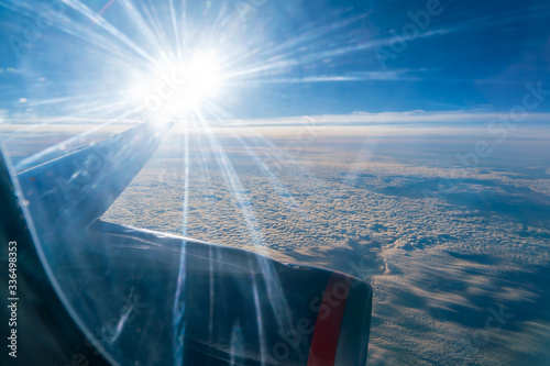 The bright sun shining in the window of an airplane