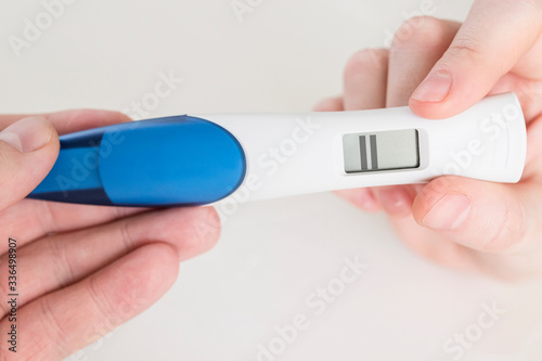 positive electronic pregnancy test in hands close up on a white background