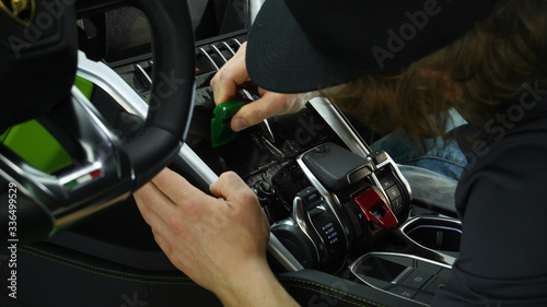 Close up of paint protection film installation on modern luxury car. PPF is polyurethane film that wrap car paint to protect paint surface from stone chips, bug splatter, and abrasion.