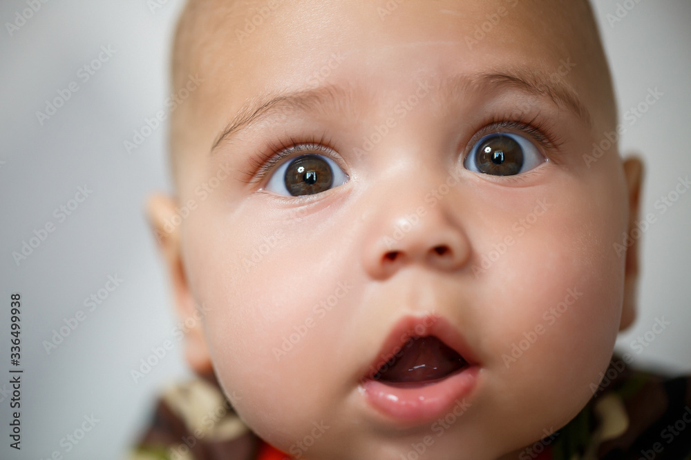 close-up portrait of a little boy age 8 months and is smiling. Dressed in military costume close-up portrait of a little boy age 8 months and is smiling. Dressed in military costume