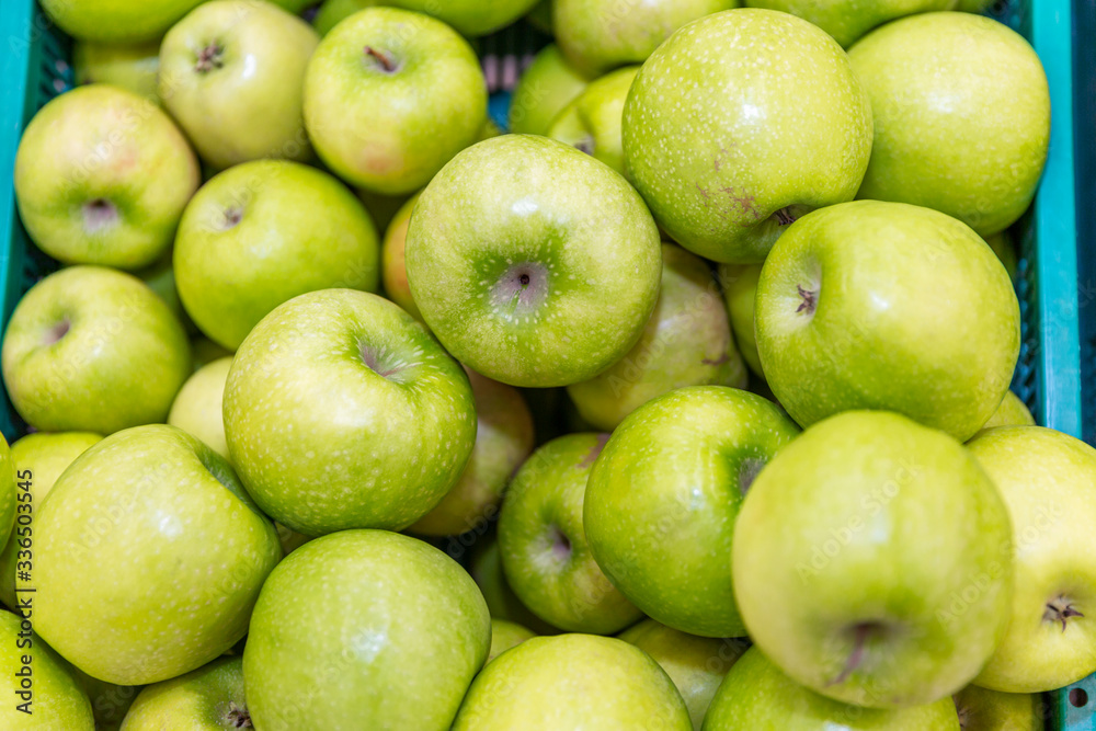 Green apples on the counter in the supermarket. Close-up. Background. Space for text. Healthy eating and vegetarianism. Green apples on the counter in the supermarket. Close-up. Background. Space for text. Healthy eating and vegetarianism.