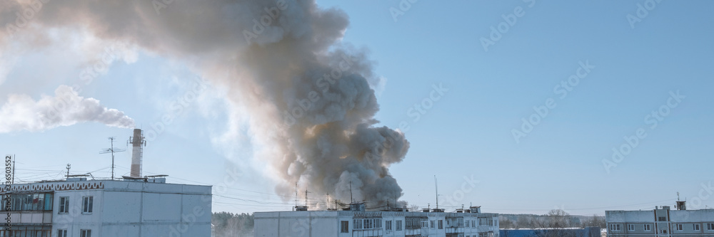 Fototapeta premium Fire in town. Burning fire with black and white smoke under house. Stok banner photo.