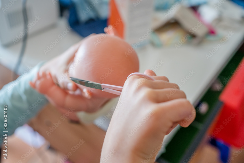 Close up on small girl hands cutting doll hair while playing indoors background. Art and craft. Creative happiness lifestyle.