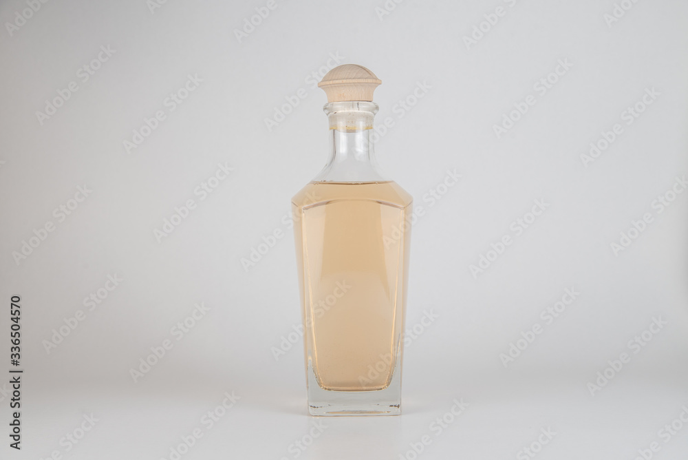 Glass bottle on light background. Closeup studio design object shot. Glass bottle on light background. Closeup studio design object shot.